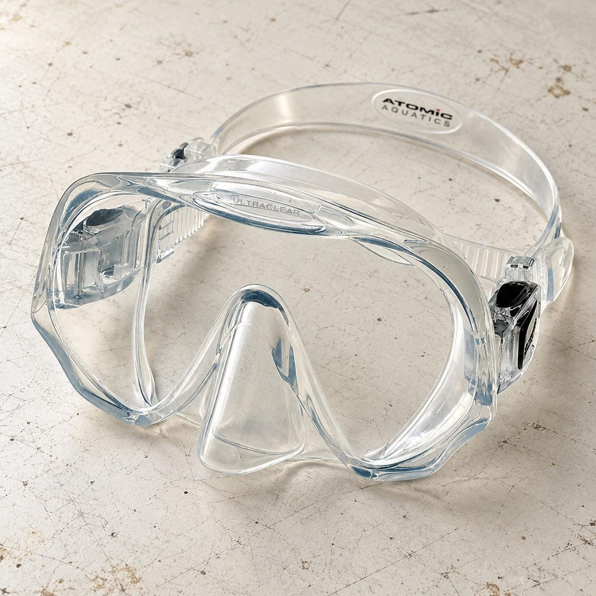 Open Box Atomic Aquatics Frameless Mask — Clear, open box, lightly used on off-white work table