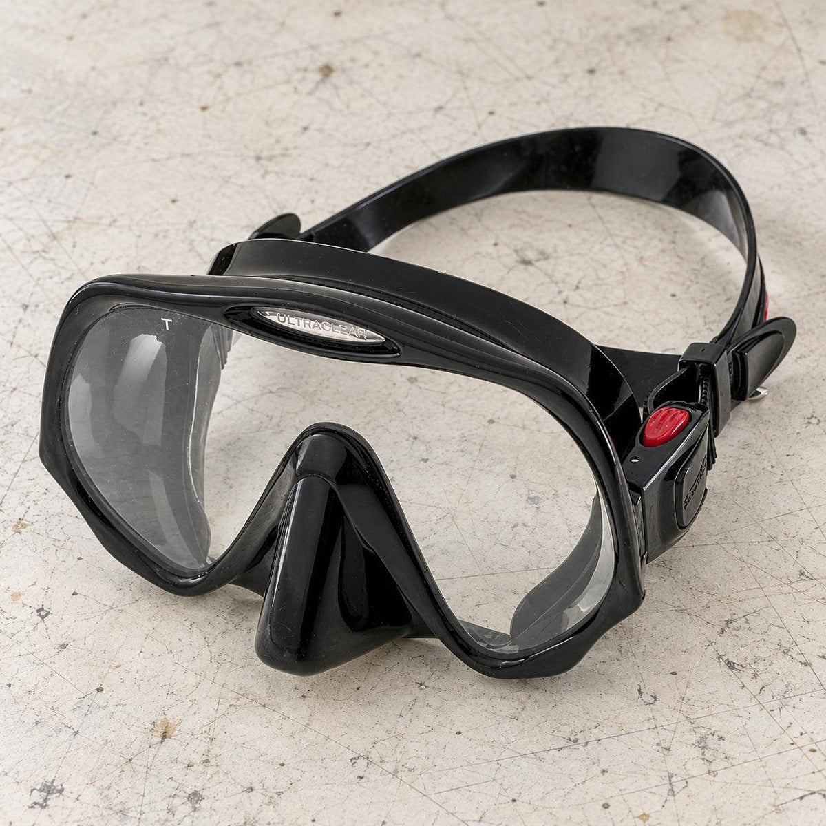 Open Box Atomic Aquatics Frameless Mask — Black, open box, lightly used on off-white work table