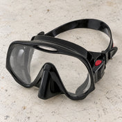 Open Box Atomic Aquatics Frameless Mask — Black, open box, lightly used on off-white work table