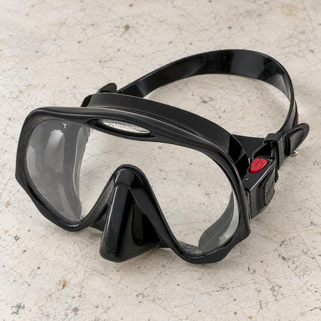 Open Box Atomic Aquatics Frameless Mask — Black, open box, lightly used on off-white work table