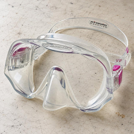 Open Box Atomic Aquatics Frameless Mask — Clear/Pink, open box, lightly used on off-white work table