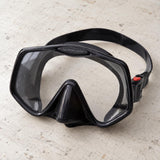 Open Box Atomic Aquatics Frameless 2 Mask — Black, open box, lightly used on off-white work table