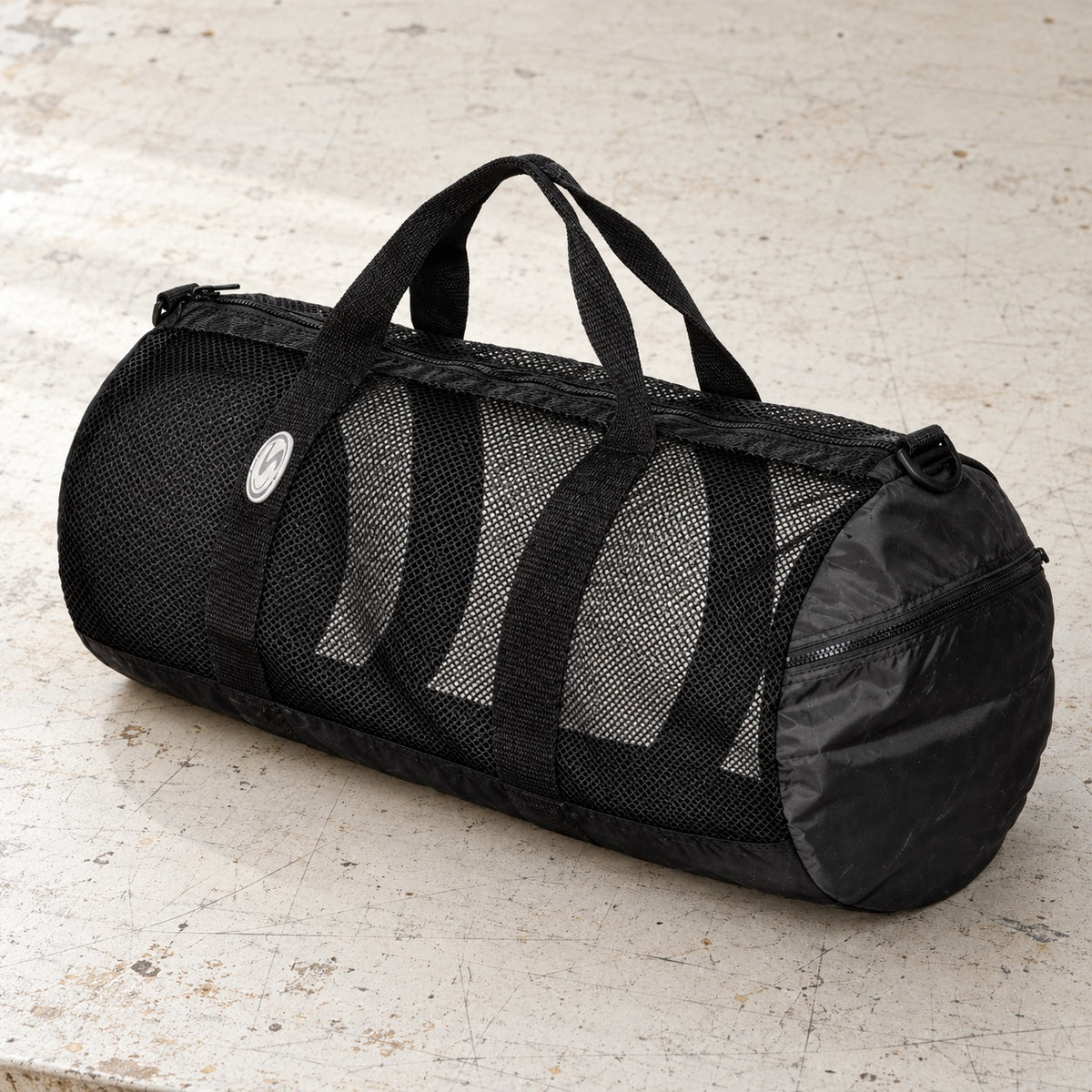 Open Box Stahlsac 26 Mesh Duffle — Black, open box, lightly used on off-white work table